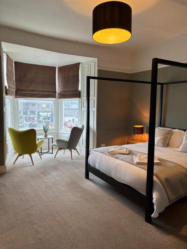 a bedroom with a bed and a table and chairs at The Mariners in Falmouth