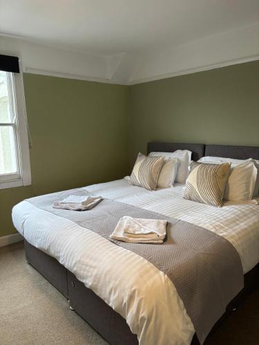 a bedroom with two beds with towels on them at The Mariners in Falmouth