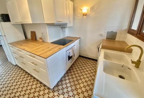 a small kitchen with white cabinets and a sink at 6-people top floor appart, calm, metro in Toulouse