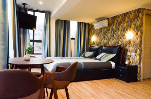 a hotel room with a bed and a table and a tv at Hotel Holitel in Parit