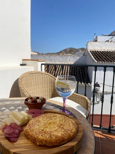 a table with a pizza and a glass of wine at Casita Maite in Ardales