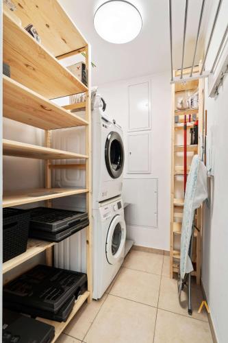 a laundry room with a washer and dryer at A Stylish Retreat in Esch Urban Landscape in Esch-sur-Alzette