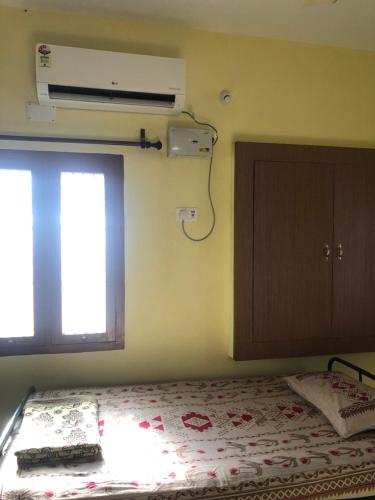 a bedroom with a bed and a window and a fan at Single room Homestay Second floor in Palani