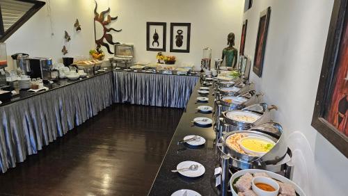 a long buffet line with plates and bowls of food at Ridee Villa in Unawatuna