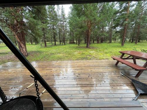 a wooden deck with a bench and a picnic table at MIDGARD LODGE - Pre-Heated with Ready Beds at Bjorli in Bjorli