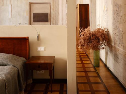 a bedroom with a bed and a table with a vase of flowers at Hotel Pod Różą in Kraków