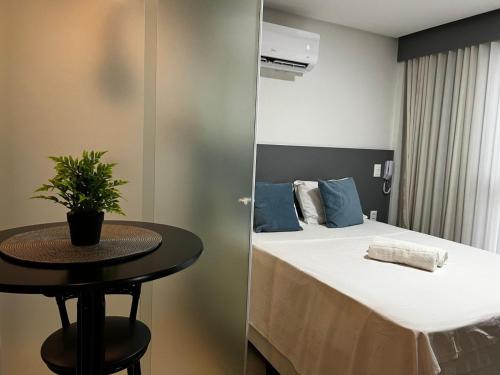 a small room with a bed and a table at Get By Side - Jardim Oceania in Tambaú