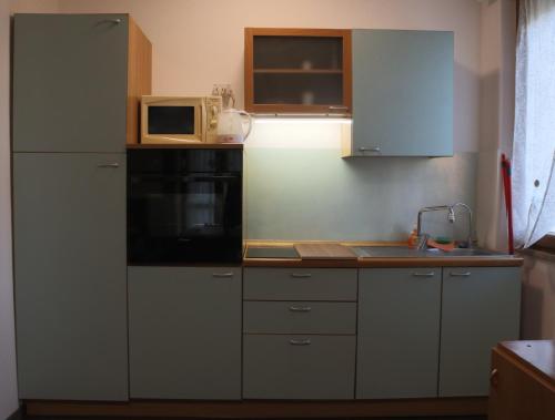 a kitchen with a microwave and a stove top oven at Casa Migliardi Colors in Nizza Monferrato