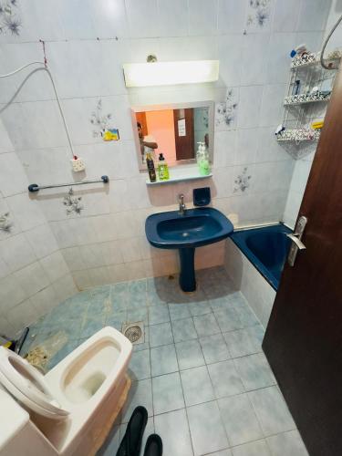 a bathroom with a toilet and a sink and a tub at The Cozy Home in Abu Dhabi