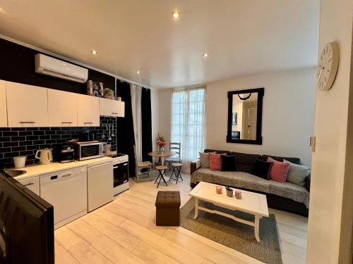 a kitchen and living room with a couch and a table at Appartement cosy in Trouville-sur-Mer