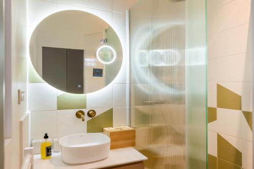 une salle de bain avec un lavabo et un miroir dans l'établissement Magnifique appartement 135m2 Jardin du Luxembourg, à Paris