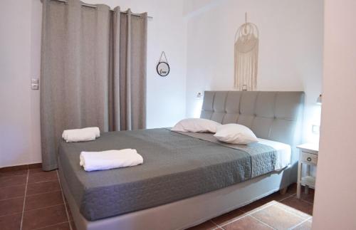 a bedroom with a bed with two towels on it at FERMINA KaGa kythnosuites in Mérikhas