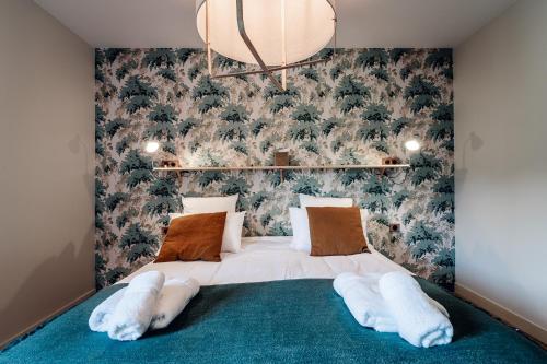 a bedroom with a large bed with a green carpet at La Maison des Pins contis in Saint-Julien-en-Born