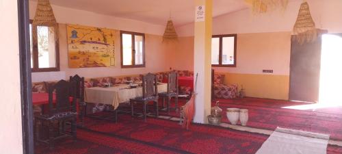 a dining room with a table and chairs in a room at Mhamid Regency Camp in Mhamid