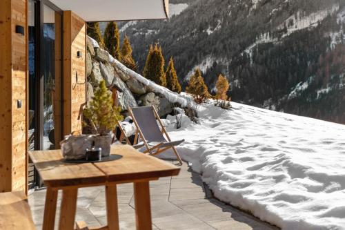 a patio with a table and a snow covered mountain at Chalet-Suite Wasser in Selva dei Molini