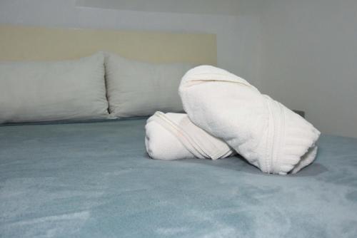 a pair of white pillows sitting on a bed at Hostel Gato Colonial in Santo Domingo