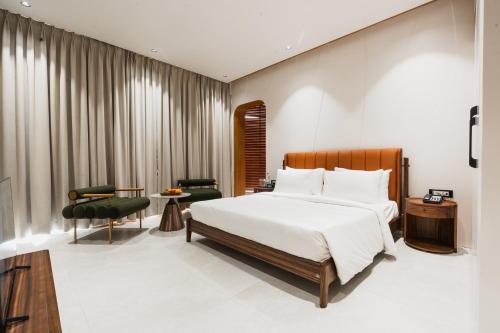a bedroom with a bed and a table and chairs at AVA Hotel Chandigarh Zirakpur in Zirakpur