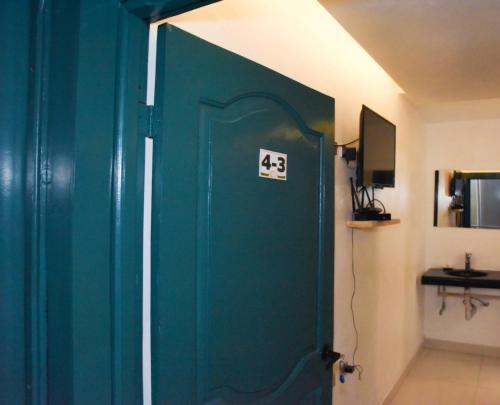 a green door in a room with a wall at Hostel Gato Colonial in Santo Domingo