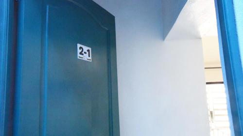 a blue door with a sign on it in a room at Hostel Gato Colonial in Santo Domingo
