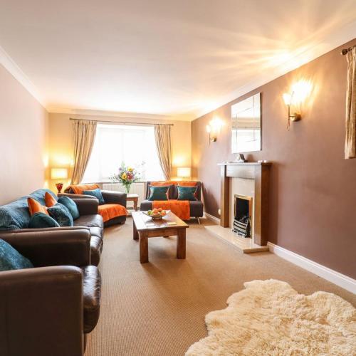a living room with couches and a fireplace at Brandeston Close in Great Waldingfield