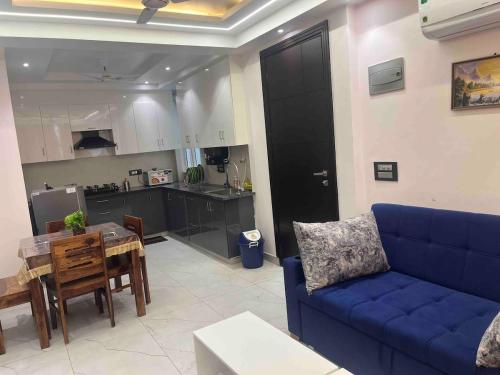a living room with a blue couch and a kitchen at Modern Luxury Deecon Valley 2BHK Flats 3Double Beds with Terrace View Tapovan Rishikesh in Rishīkesh