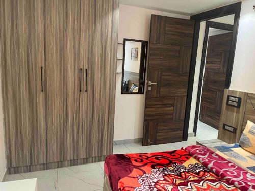 a bedroom with a large wooden closet and a bed at Modern Luxury Deecon Valley 2BHK Flats 3Double Beds with Terrace View Tapovan Rishikesh in Rishīkesh