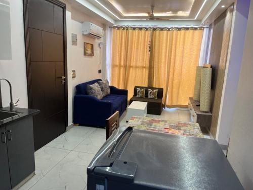 a living room with a blue couch and a table at Modern Luxury Deecon Valley 2BHK Flats 3Double Beds with Terrace View Tapovan Rishikesh in Rishīkesh