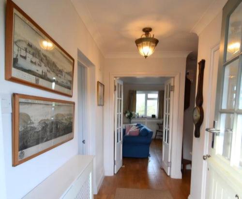 a hallway of a home with a blue couch at 2 Steepfield, Bantham with estuary views in Bigbury on Sea