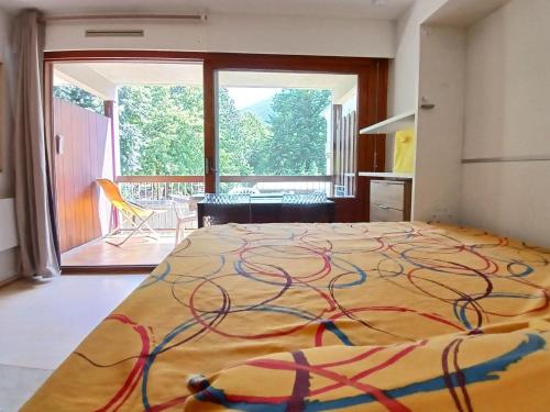 - une chambre avec un lit et une couverture colorée dans l'établissement La Pique, à Luchon