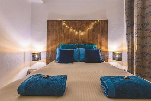 a bedroom with a large bed with blue pillows at Azul Cosy charmant proche centre in Reims