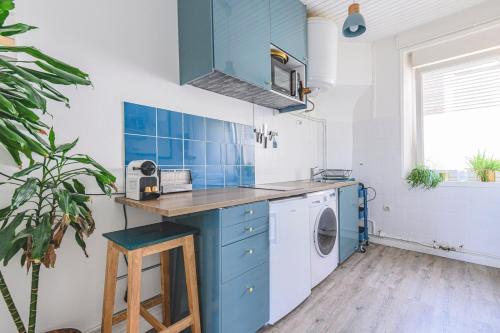 - une cuisine bleue et blanche avec un lave-linge dans l'établissement Azul Cosy charmant proche centre, à Reims