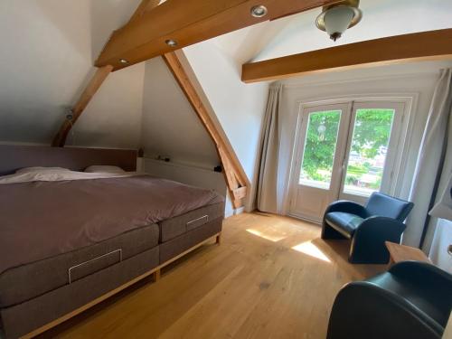 アッカースロートにあるVilla free standing 25 min Amsterdam 10 min beachのベッドルーム1室(ベッド1台、青い椅子2脚付)