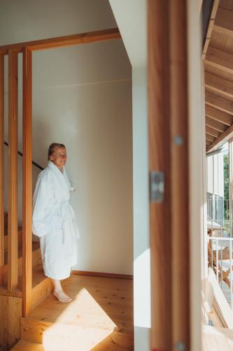 a woman in a robe standing in a room at Thalers Mariandl in Schladming