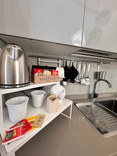 a kitchen with a sink and a shelf with utensils at Isabel’s house in Vietri sul Mare