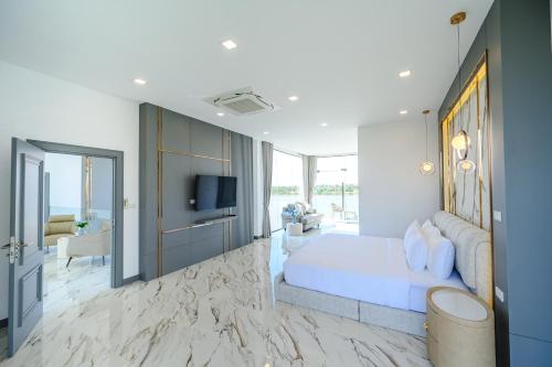 a bedroom with a large bed and a television at Sararin Luxury Villas in Nong Khai