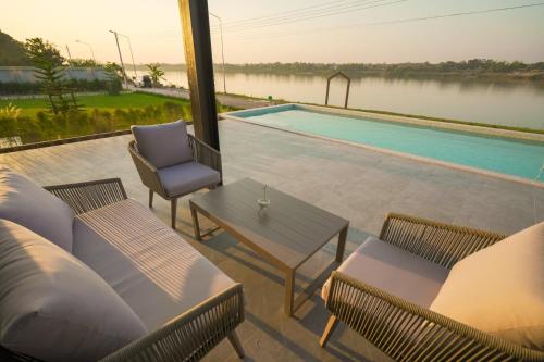 a patio with a table and chairs and a pool at Sararin Luxury Villas in Nong Khai