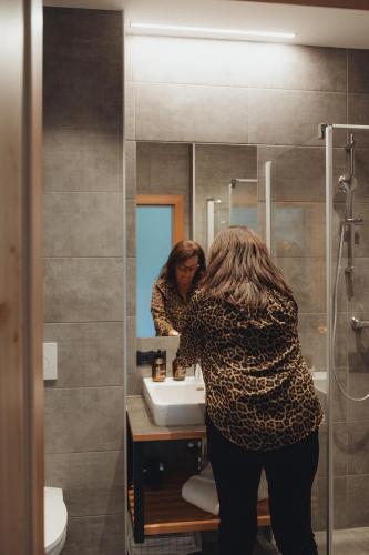 a woman standing in front of a bathroom mirror at Thalers Mariandl in Schladming
