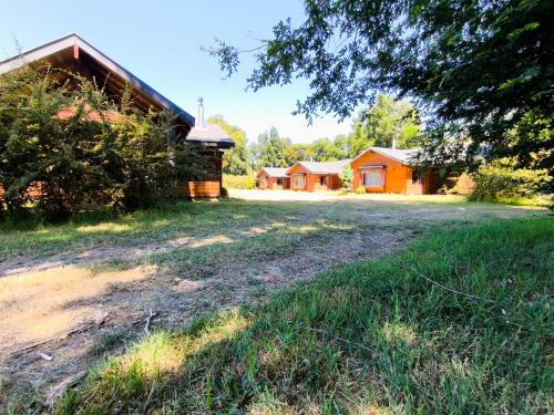 an image of a house with a yard and a church at Cabañas Santa Maria Huife in Pucón