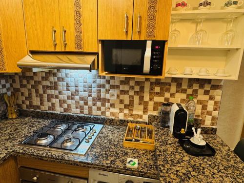 a kitchen counter top with a stove and a microwave at Modern Apartment in the heart of Tangier in Tangier
