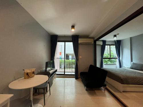 une chambre avec un lit, un bureau et une table dans l'établissement Zcap3 condo central Phuket, à Ban Rangeng