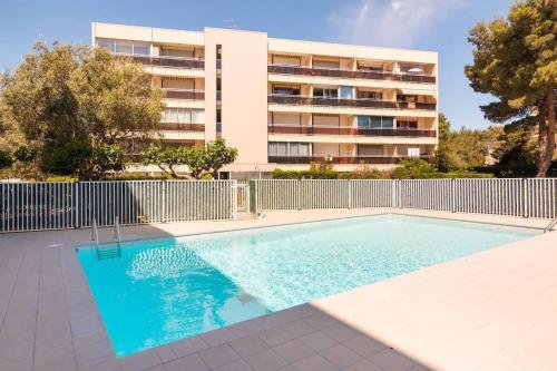 une piscine devant un immeuble dans l'établissement Studio moderne et cosy, à Canet