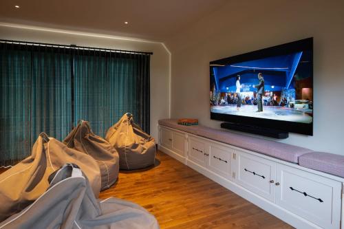 a living room with a flat screen tv and a couch at Yellow Sands in Thurlestone
