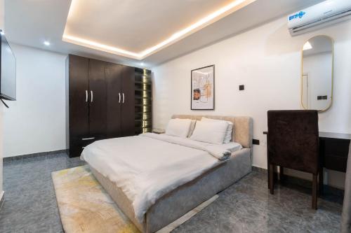 a bedroom with a bed and a desk and a table at LUXURY 3 bedroom Apartment Victoria Island Lagos with swimming pool play station 5 Netflix in Lagos