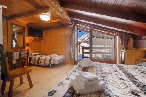 a room with two beds and a window in a house at Arthemisia - Rhêmes-Notre-Dame in Rhêmes-Notre-Dame