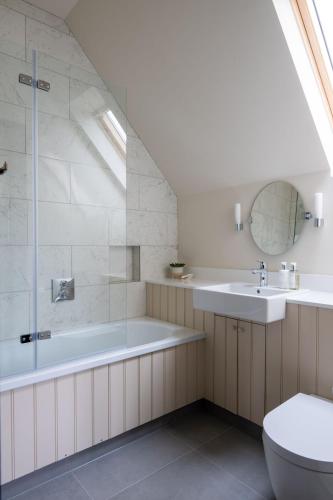 a bathroom with a tub and a toilet and a sink at Yellow Sands in Thurlestone