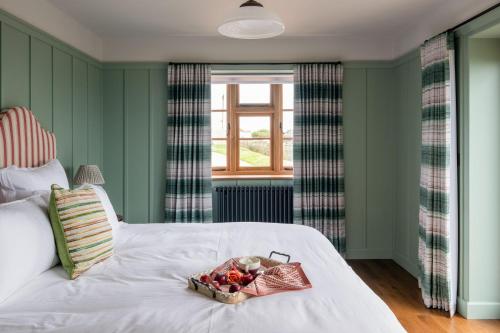 a bedroom with a bed with a tray of fruit on it at Yellow Sands in Thurlestone