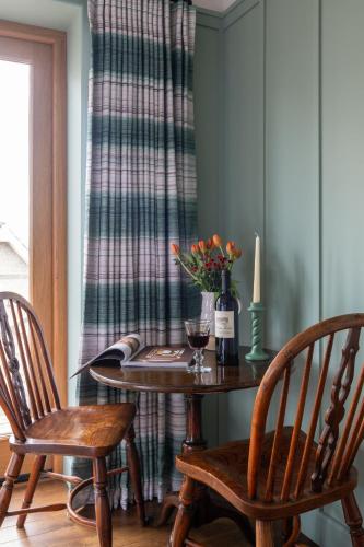 a table with two chairs and a candle and flowers on it at Yellow Sands in Thurlestone