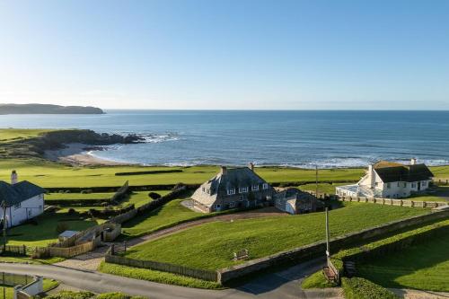 an aerial view of a house and the ocean at Yellow Sands in Thurlestone