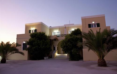 a large building with palm trees in front of it at Giosifaki in Vari