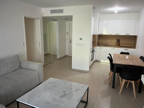un salon avec un canapé et une table dans l'établissement 2 Bedroom Apartment Near Beach, à Mandelieu-la-Napoule